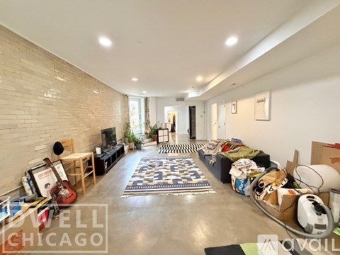 A room with a guitar, a chair, and a box on the floor.