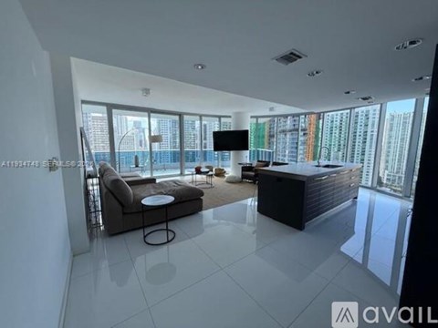 A modern living room with a flat screen TV and a view of the city.