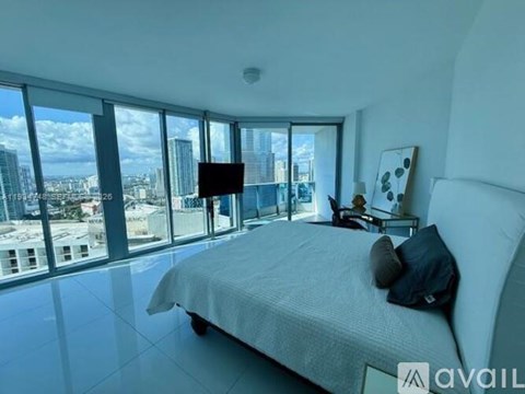 A bedroom with a large bed and a view of the city.