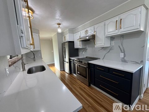 A kitchen with white cabinets and a black stove top oven.