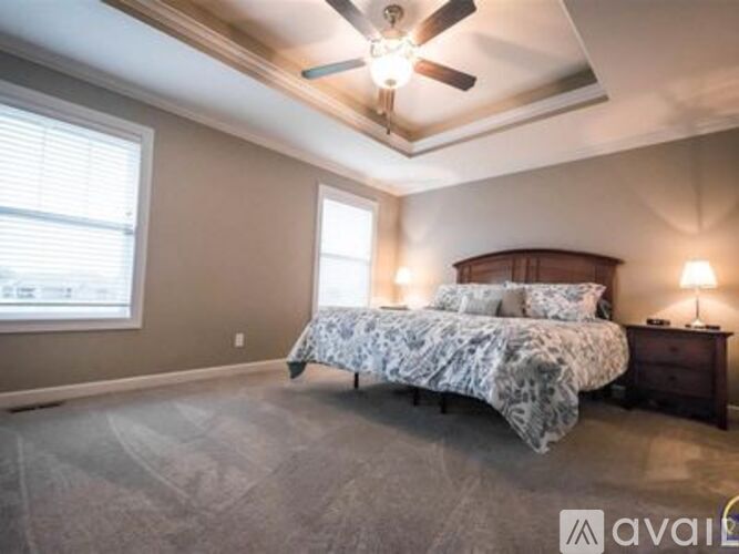 A bedroom with a bed and a ceiling fan.