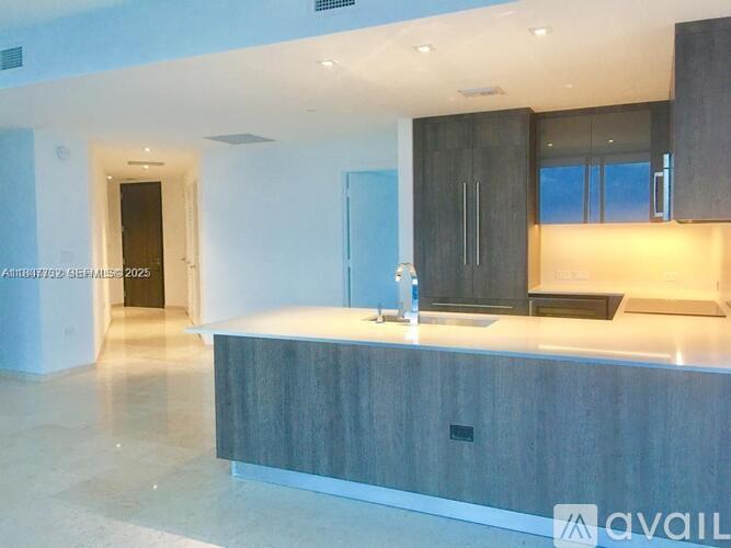 A modern kitchen with a wooden island and a sink.