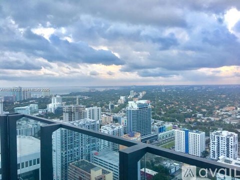 A cityscape with a mix of modern and older buildings under a cloudy sky.