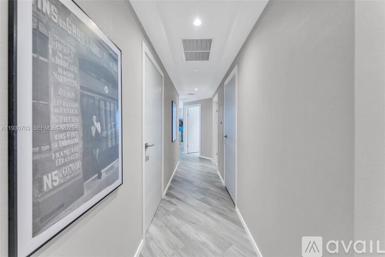 A long hallway with a framed poster on the wall.