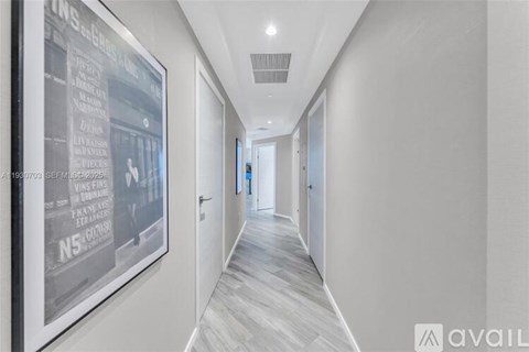 A long hallway with a framed poster on the wall.