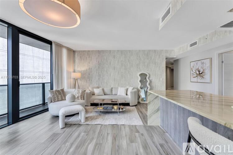 A modern living room with a white sofa set and a wooden floor.
