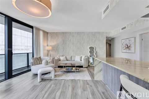 A modern living room with a white sofa set and a wooden floor.