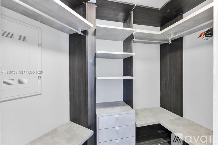 A modern kitchen with white cabinets and a stainless steel range hood.