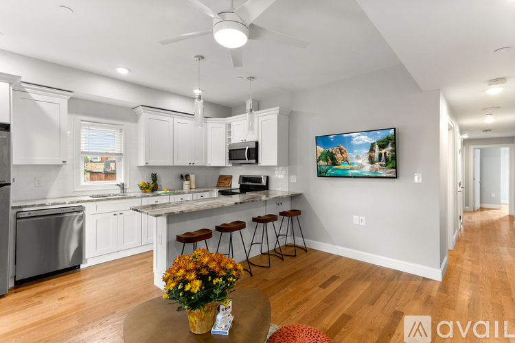 A kitchen with white cabinets and a wooden floor.