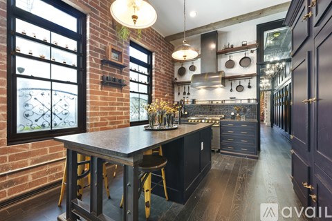 A kitchen with a brick wall and a table with chairs.