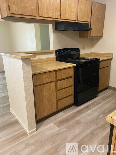 A kitchen with wooden cabinets and a black stove top oven.