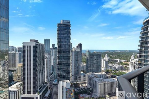 A cityscape with a tall building in the foreground and other buildings in the background.