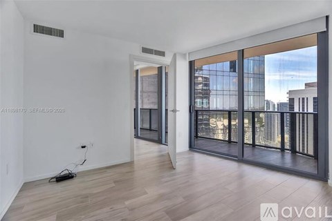 A room with a view of the city through large windows.