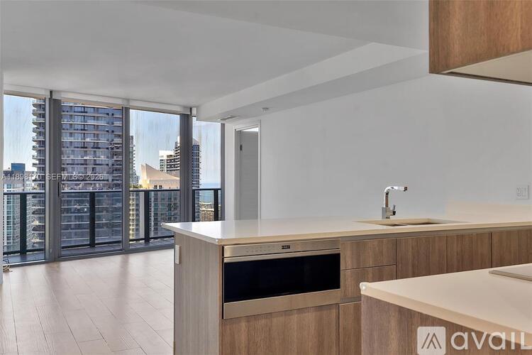 A modern kitchen with wooden cabinets and a stainless steel oven.
