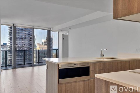 A modern kitchen with wooden cabinets and a stainless steel oven.