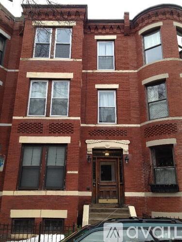A red brick building with a wooden door and windows.
