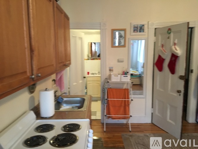 A kitchen with a white stove top oven and wooden cabinets.