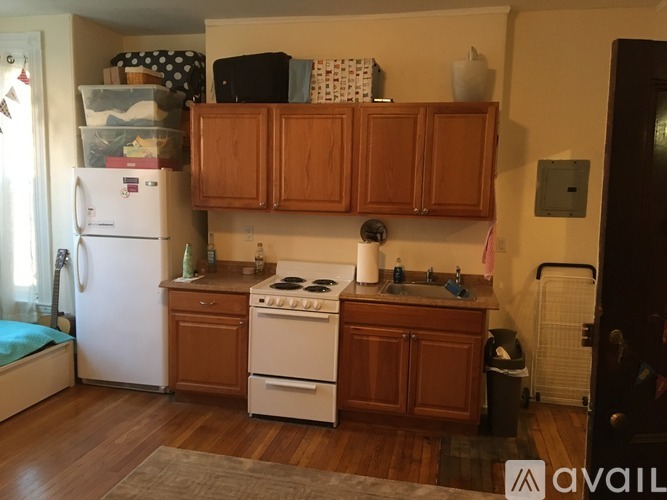 A kitchen with wooden cabinets and a white fridge.