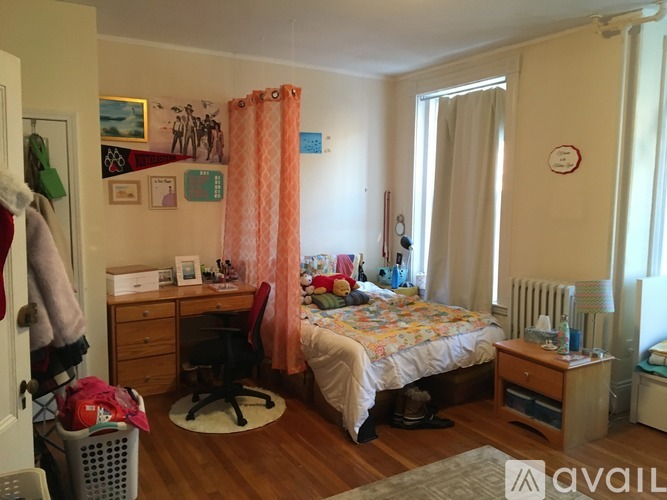 A bedroom with a bed, desk, and chair.