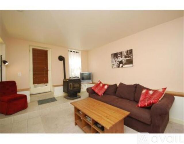 A living room with a red couch and a wood coffee table.