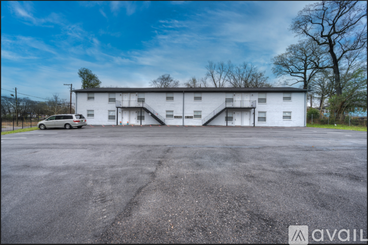 A large white building with a car parked in front of it.