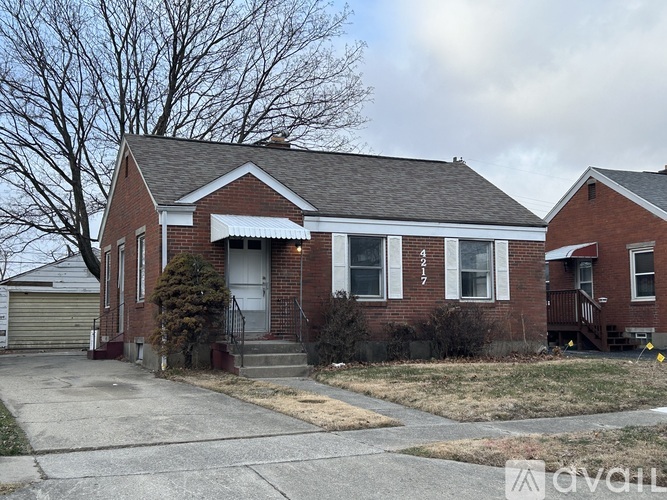 A red brick house with a white door and a small front yard.