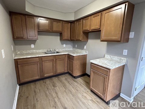 A kitchen with wooden cabinets and a marble countertop.