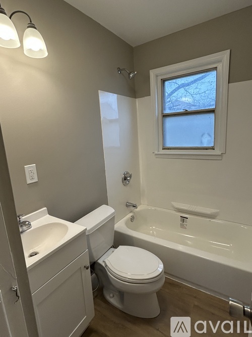 A bathroom with a toilet, sink, and bathtub.