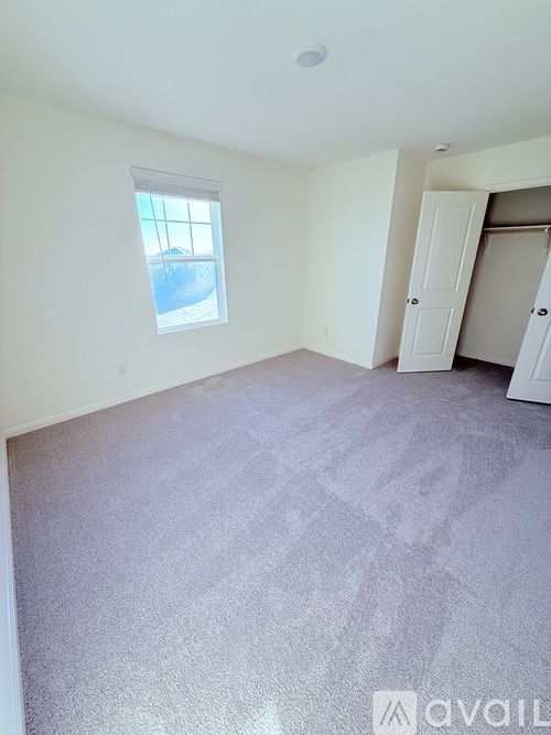 A room with a window and a door is available for rent.