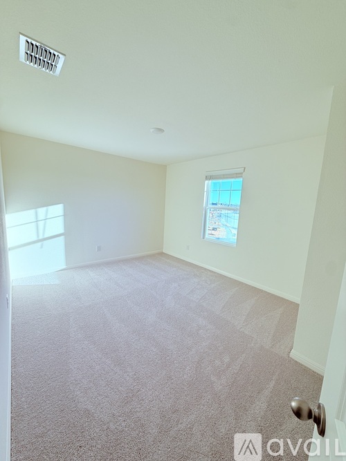 A room with a carpeted floor and a window.