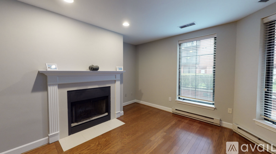 A living room with a fireplace and wooden floors.