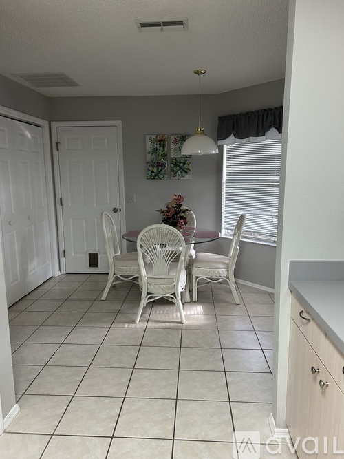 A dining room with a table set for four.