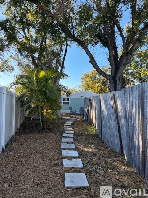 A garden pathway with stepping stones between trees.