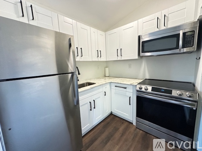 A kitchen with a stainless steel refrigerator, microwave, and oven.