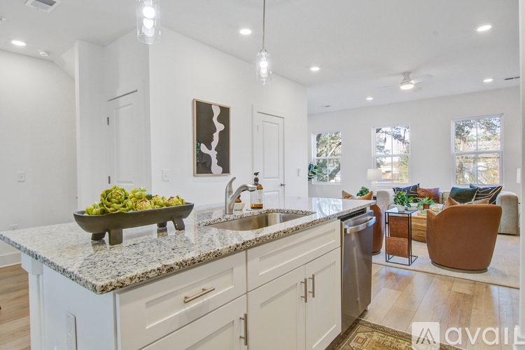 A kitchen with a granite countertop and a bowl of green vegetables on it.
