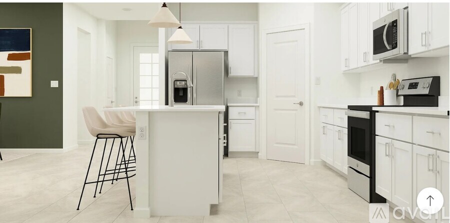 A kitchen with white cabinets and a white island with a bar stool.