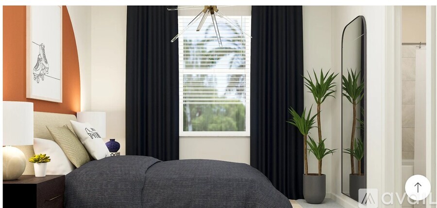 A bedroom with a large bed and a window with black curtains.