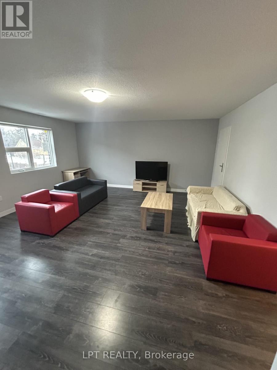 A living room with a red couch and a wooden table.