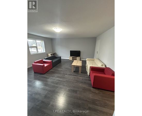 A living room with a red couch and a wooden table.