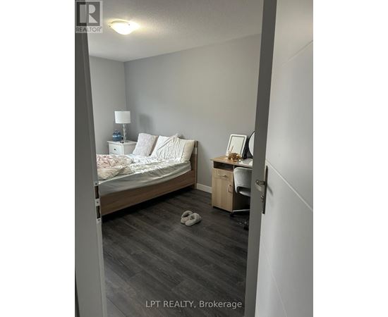 A bedroom with a bed, desk, and chair.
