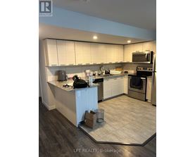 A kitchen with a white counter top and a black bag on it.