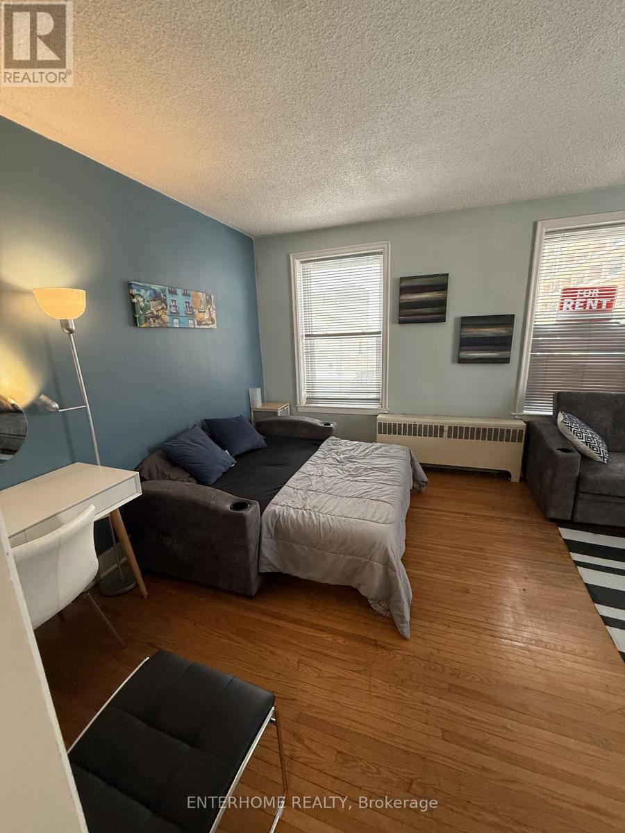 A bedroom with a bed, couch, and chair.