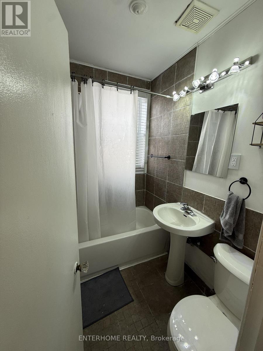 A bathroom with a toilet, sink, and shower.