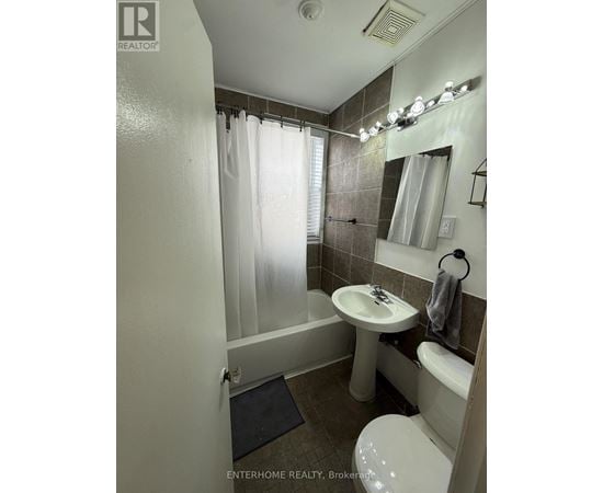 A bathroom with a toilet, sink, and shower.