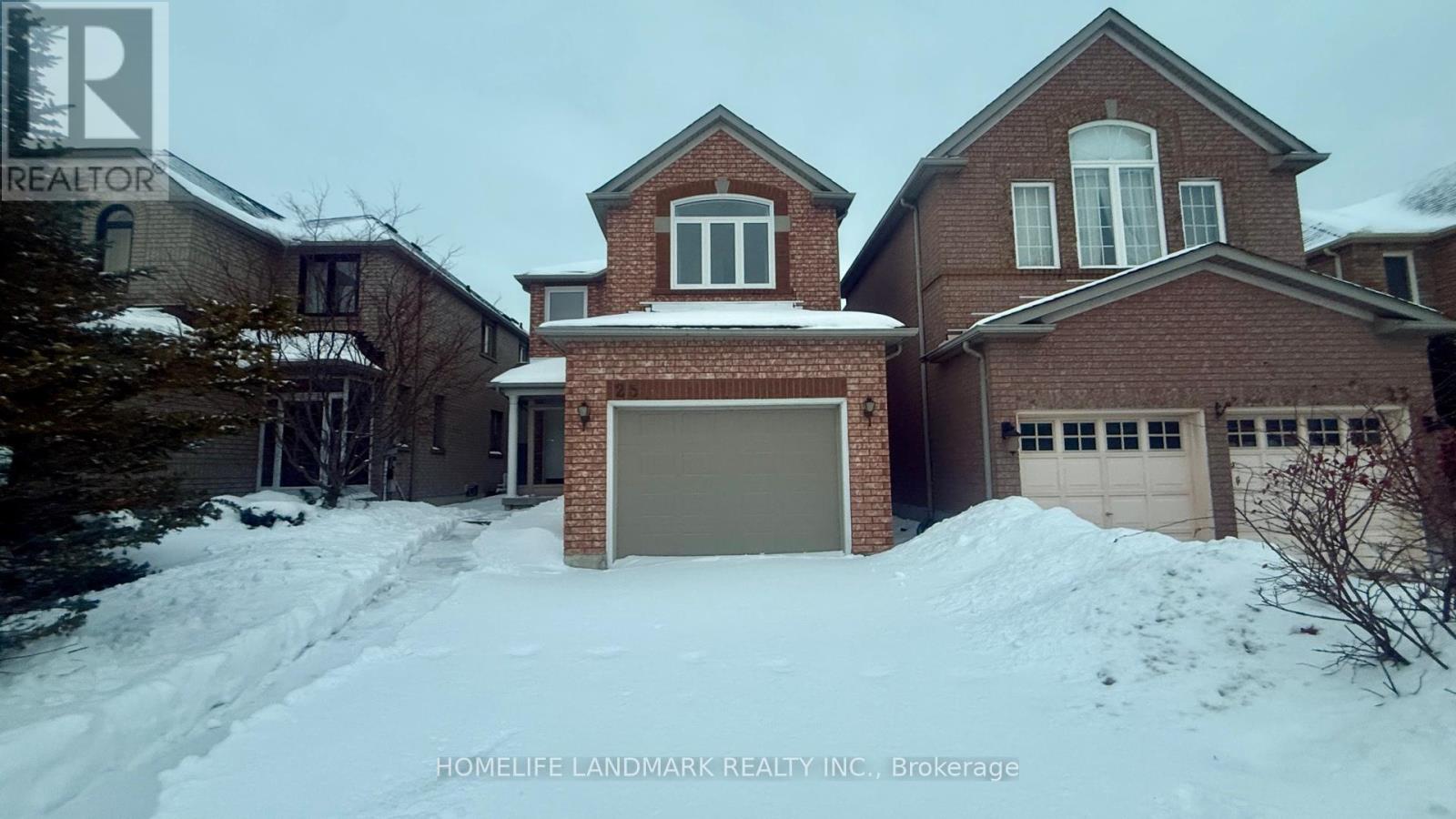 A large brick house with a snow-covered driveway in front.