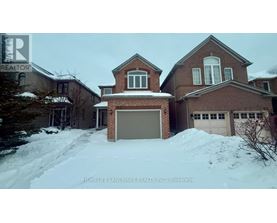 A large brick house with a snow-covered driveway in front.
