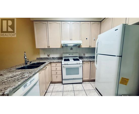 A kitchen with a white refrigerator and white appliances.