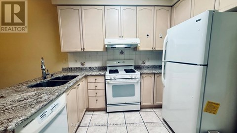 A kitchen with a white refrigerator and white appliances.