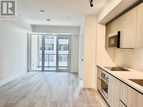 A kitchen with a sink, stove, and oven with a microwave above it.