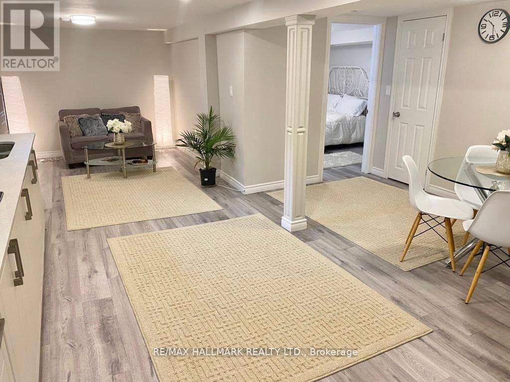 A living room with a couch, a chair, and a dining table.